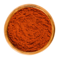 Sweet pepper red paprika powder in wooden bowl. Ground spice made from air-dried and smoked bell...