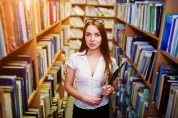 Brunette girl at library with folder of documents, wear on white blouse and black mini skirt. Sexy business woman or teacher concept.
