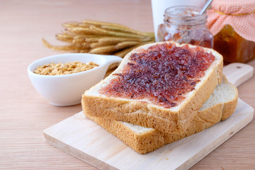 Bread with jam grape on wood background