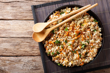 Thai cuisine: fried rice with minced meat and vegetables close-up on the table. Horizontal top view