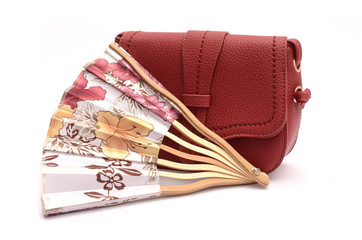 Red leather clutch and hand fan still life