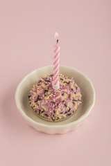 Fototapeta na wymiar birthday cake with one candle on pink