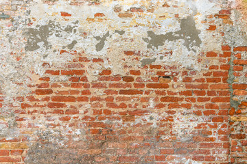 Obraz premium Old brick wall texture, covered with multiply stucco plaster and paint layers, weathered and distressed