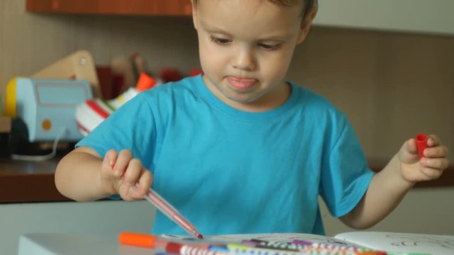 Little boy drawing with felt pens.