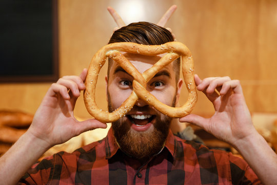 Happy Man In Supermarket Holding Pretzel