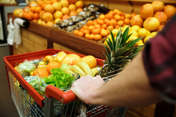 Cropped image of young man with shopping trolley