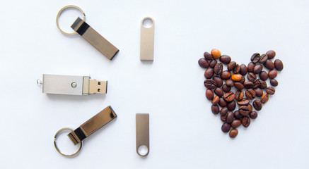 USB stick and heart from coffee beans on white background.