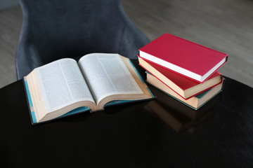 Open book and hardcover books on wooden table in library. Education background.