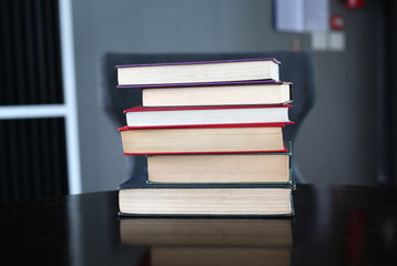 stack of hardcover books on wooden table. Education background.