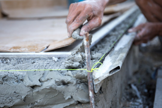 man shape the edge of the floor with plasterer concrete cement