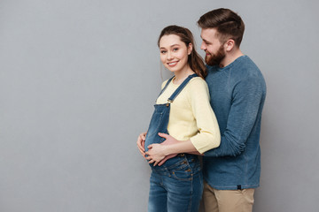 Pregnant happy woman hugging cheerful man