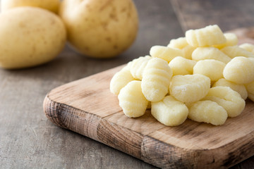 Uncooked potato gnocchi on wooden table

