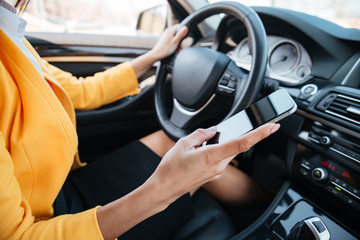 Young woman driver using touch screen smartphone