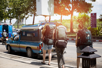 backpacker travelers getting taxi on the street