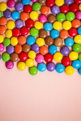 Multi-colored candies on pink background