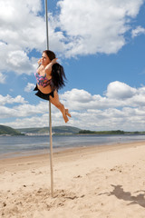 dancer on pole performs acrobatic