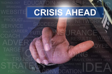 Businessman touching CRISIS AHEAD button on virtual screen
