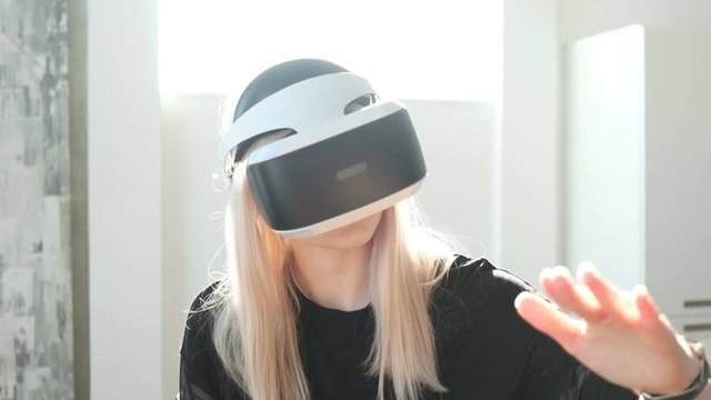 Beautiful young female playing game in virtual reality glasses. Beautiful woman touch something using modern virtual reality glasses