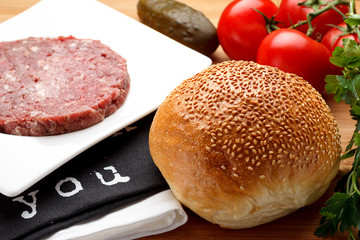 Kitchen. Fresh ingredients are ready for preparing a burger. Wooden background.