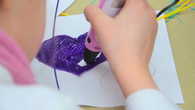 Woman teaches child to use a 3D pen
