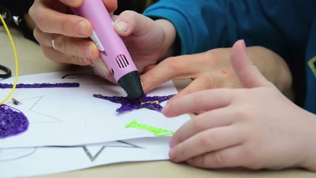 Woman teaches child to use a 3D pen
