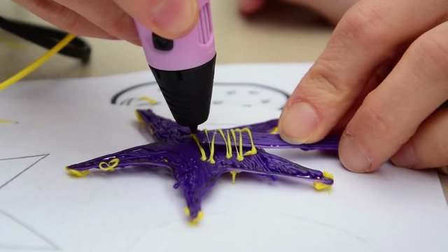 Woman teaches child to use a 3D pen
