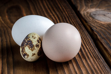 Chicken and quail eggs on a wooden background