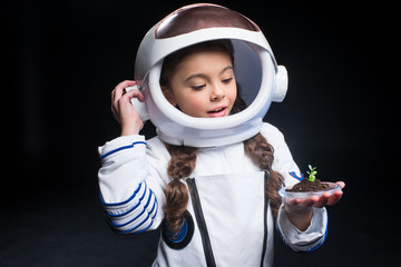 Girl astronaut holding plant © LIGHTFIELD STUDIOS