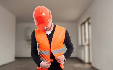 Young male constructor adjusting his protection  vest