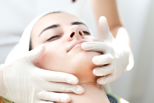 Relaxing facial massage.Beautiful young woman receiving facial massage at spa