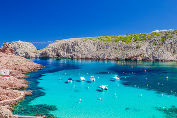 Cala Morell cove with its red rocks and crystal clear blue water - obrazy, fototapety, plakaty
