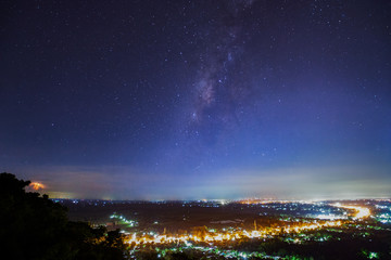 Fototapeta premium City landscape at nigh with Milky Way galaxy, Long exposure photograph.with grain
