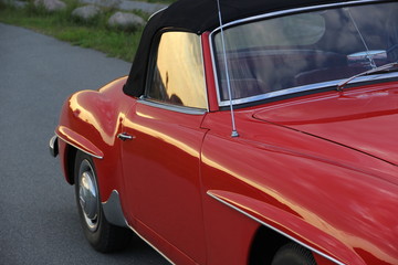 Abendsonne scheint ins Seitenfenster von einem rotem Cabrio