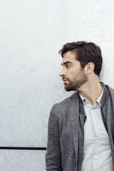 Stubble guy in grey jacket, looking away