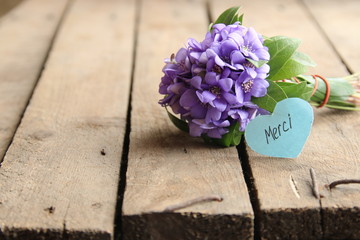 Merci written on tag and flowers
