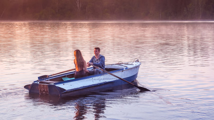 Romantic golden sunset river lake fog loving couple small rowing boat date beautiful Lovers ride...