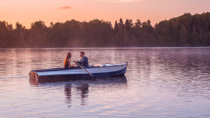 Fototapeta na wymiar Romantic golden sunset river lake fog loving couple small rowing boat date beautiful Lovers ride during Happy woman man together relaxing water nature around