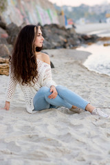 Woman with perfect hair sitting near the beach