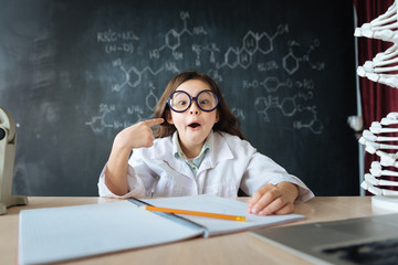 Amazed little girl studying chemistry in the laboratory