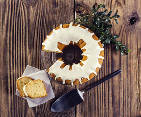 Obraz na płótnie Canvas Glazed easter cake and boxwood on a wooden table, top view