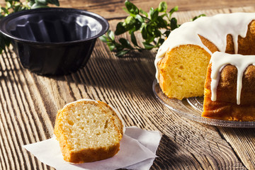 Homemade glazed easter cake and some slices on a wooden table