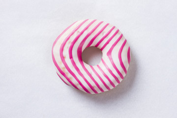 Donut with white icing and pink stripes isolated on white