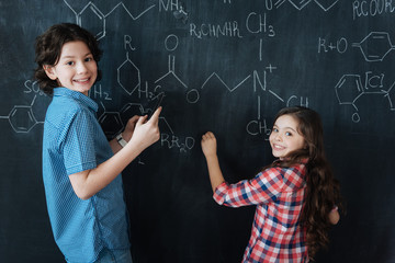 Satisfied teenagers enjoying chemistry class at school