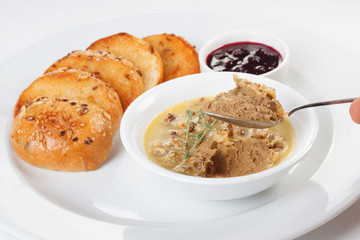 Pate for sandwiches on a spoon holds a hand on a white background isolated