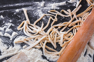 Cooking noodles concept on black background, sprinkled flour with copy space