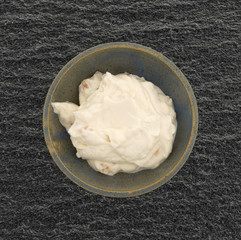Apple Greek yogurt in a stoneware bowl on a black slate table top.
