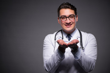 Young doctor against dark background