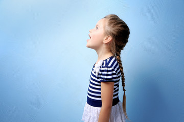 Cute little girl on color background