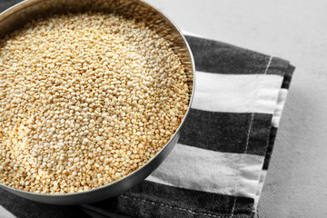 Organic quinoa seeds in bowl on striped napkin