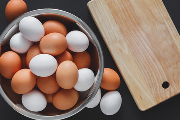 Fresh brown eggs in bowl isolated on black background